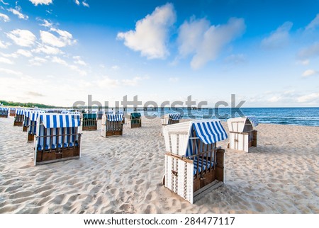 Closed wicker beach chairs on empty sandy beach at Baltic Sea, calm before rush