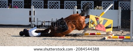 A rider falls from a horse during a show jumping competition. An equestrian accident. The rider and horse were not injured. Foto stock © 
