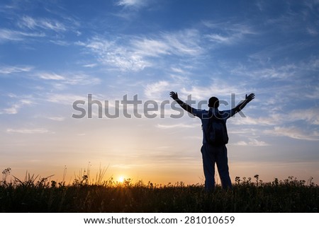Silhouette of man with arms raised up and beautiful sky. Element of design. Summer sunset. Background