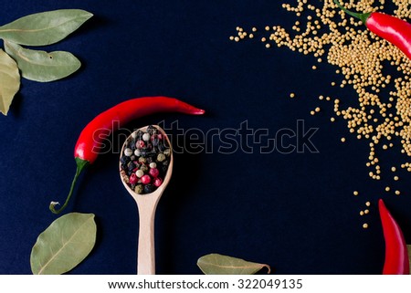 Food spice seasoning ingredients for cooking in cuisine on dark background in the wooden spoon. Dry powder curry, ginger, cardamon, chili, laurel. Asian  yellow, green colorful aroma condiment.