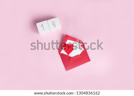 Valentine's day concept. Valentine, hearts, wooden cubes with numbers on a pink background. Holidays.