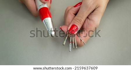 Manicure milling and cutters in women's hands. Device for removing gel varnish. Banner for insertion into site. Place for text cope space. Electric manicure machine Photo stock © 