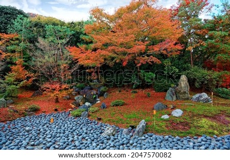 Fall scenery of the Japanese garden (獅子吼の庭) of Hogon-in (宝厳院) Buddhist Temple in Arashiyama (嵐山), Kyoto, Japan, with stone landscaping under fiery maple trees and red fallen leaves on the mossy ground 商業照片 © 