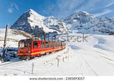 Similar – Foto Bild Ein schneeweisser ICE Zug mit einem dicken roten Streifen verlässt gerade München Hauptbahnhof. In seinen Fenstern spiegelt sich die Bahnhofshalle mit Neonleuchten, das graue Pflaster des Bahnsteigs zeigt einen weißen Streifen