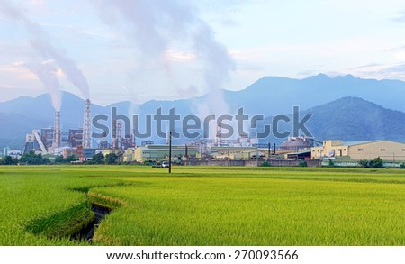 Factory in the middle of a green Farmland on a cloudy day