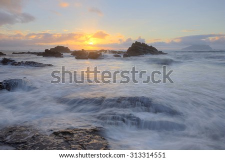 Golden rays of the rising sun light up the rocky beach at Wai\'ao, Ilan, Taiwan (Long Exposure Effect)