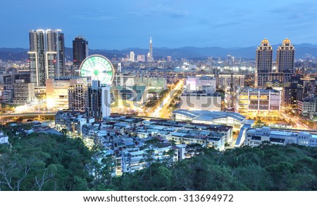 Aerial panorama of busy Taipei City ~ with a view of ferris wheel in Dazhi Commercial District, and Taipei Xin-yi District in the downtown area in twilight