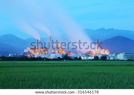 View of a factory in the middle of a green farmland in the early morning