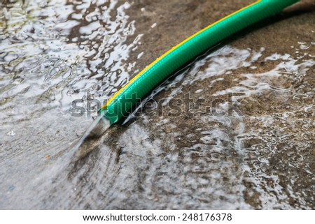 Green rubber tube open water on the cement floor