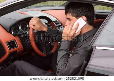 Driver inside the luxury sports car talking on the phone