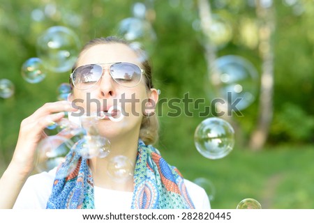 Young woman making soap bubbles outdoor