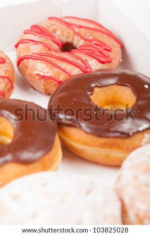 A low angle view of variety of donuts in a box. Shallow Depth of Field.