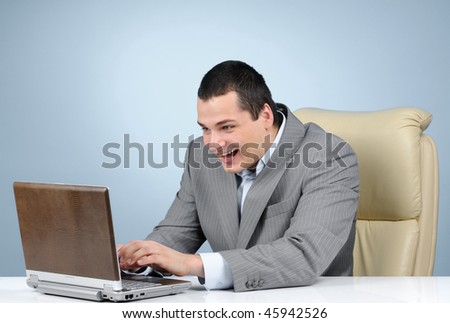 Businessman playing video game at working hours on gray background