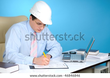 An engineer with white hard hat at work on blue background