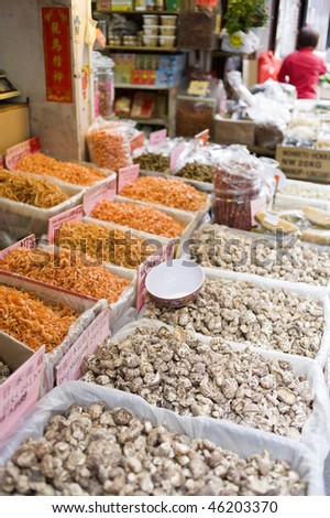 dried fish, nuts, fruit, seeds, and mushrooms displayed in bins on the sidewalk outside a store in Chinatown, New York