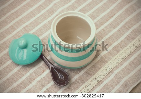 Green pastel porcelain jar and brown spoon in vintage style.