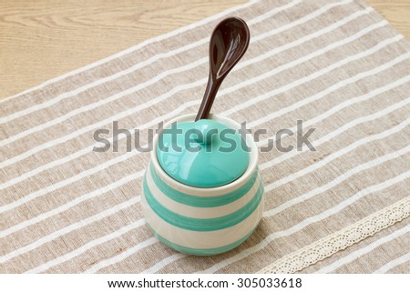 Green pastel porcelain jar and brown spoon with cute fabric.