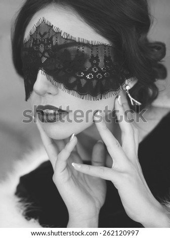 black and white fashion photo of beautiful sexy woman in lace mask with luxurious straight hair
