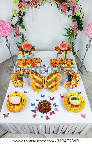 Wedding Fruits at banquet table.Buffet reception with fruit. Catering for wedding. Pyramid with tropical fruit on the wedding banquet