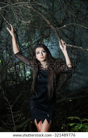 Beautiful woman lost in the wood. Lost girl in forest. Woman lost, sad, disoriented and scared. Brunette woman portrait in forest
