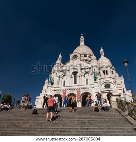 PARIS - SEPT 16, 2014: Tourists near the Basilica of the Sacred Heart of Paris (Sacra-Coeur) is a Roman Catholic church. Located at the summit of the butte Montmartre. Paris, France.