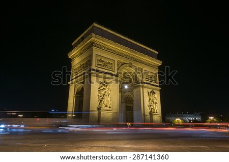 PARIS - SEPT 16, 2014: The Arch of Triumph of the Star (The Arc de Triomphe de l'Etoile) and traffic lights at night. Paris, France.