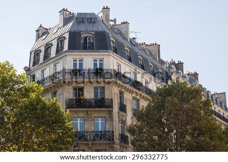 Typical design of Parisian architecture. The facade of french building in modern style with windows and french balconies in Paris, France.