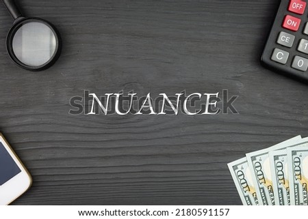 NUANCE - word (text) and money dollars on the table, phone magnifying glass (loupe) and calculator. Business concept, buying goods and products, paying for services (copy space). Imagine de stoc © 