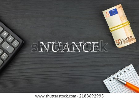 NUANCE - word (text) and euro money on a wooden background, calculator, pen and notepad. Business concept (copy space). Imagine de stoc © 