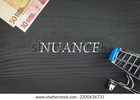 NUANCE - word (text) and euro money on a wooden background, trolley (basket) for goods. Business concept, buying goods and products (copy space). Photo stock © 