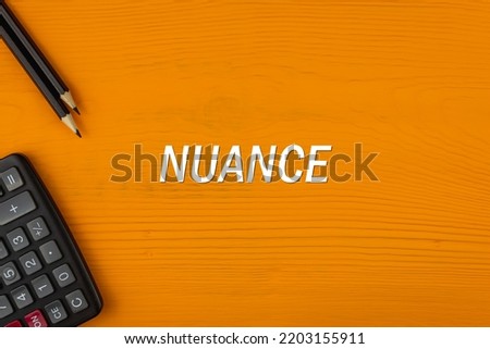 NUANCE - word (text) on a yellow wooden background, a calculator and a pencil. Business concept (copy space). Photo stock © 