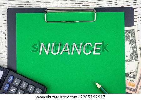 NUANCE - word (text) dollar bills on green background, pencil, calculator and wooden white table. Business concept: buying, selling, commerce (copy space). Photo stock © 