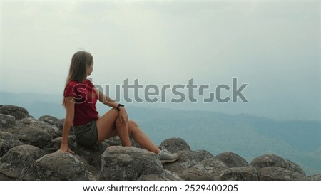 Similar – Image, Stock Photo Lone female hiker contemplating the clouds from the top of a mountain