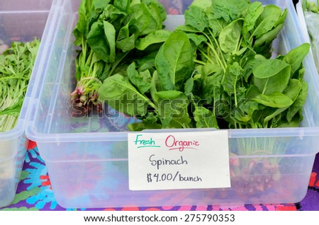 a box  of fresh organic spinach in the Fruits and Vegetables stall at University District farmer market (aka U-district) in Seattle, WA, USA