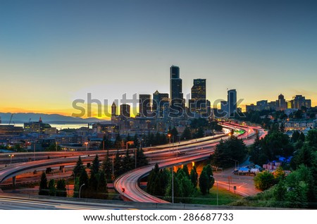 Seattle skylines and highway traffic motion in the sunset. The view from Rizal Park in Seattle, Washington, US. City scape and high speed concept.