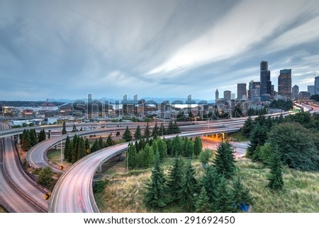 SEATTLE, WASHINGTON, US - JUNE 23, 2015 - Seattle skylines and highway traffic motion in the sunset with cloud storm. The view from Rizal Park in Seattle, Washington, US. Motion and high speed concept