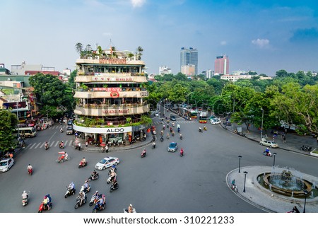 HANOI, VIETNAM - AUG 26,2015: Vehicles running on a busy street near Hoan Kiem lake (Sword lake) in Hanoi capital, Vietnam. This area is located in the old quarter, the center of Hanoi