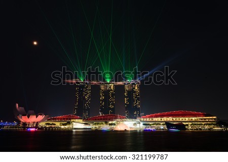 Full moon and lighting show over Singapore landmarks and tourist attraction. Mid-autumn is a big holiday in Asia. People celebrate full moon with moon cake, street lion dancing and flying lantern