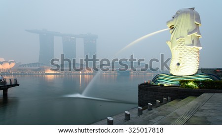 SINGAPORE-SEP 24, 2015: Haze fills the Marina Bay area. Haze is caused by the forest fire and burning of plantation in Indonesia. Also visible is the Merlion statue and Marina Bay Sands luxury hotel