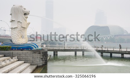 SINGAPORE-SEP 24, 2015: Haze fills the Marina Bay area. Haze is caused by the forest fire and burning of plantation in Indonesia. Also visible is the Merlion statue and Esplanade Theatres on the Bay