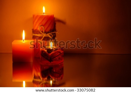 Three candles on orange background