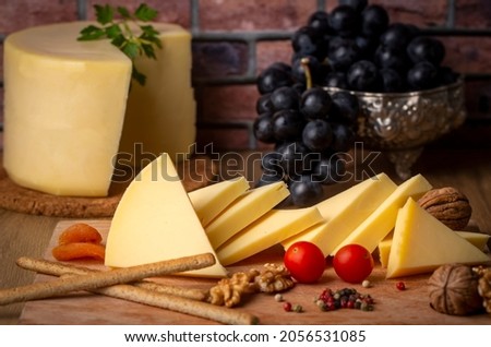 Kashar cheese or kashkaval cheese on wood floor. Cheese slices on the serving board