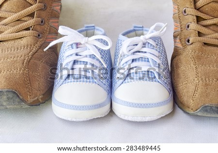 big shoes of father and small baby shoes