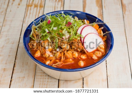 Red pozole soup on a white wooden background