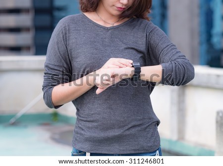 A female(woman) looking at her smart watch