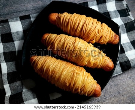 Sosis gulung mie or sausage roll noodles served on black plate Zdjęcia stock © 
