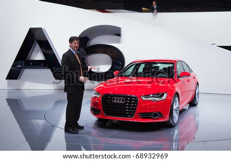 DETROIT - JANUARY 11: A reporter talks about the new Audi A6 at the 2011 North American International Auto Show Press Preview on January 11, 2011 in Detroit, Michigan.