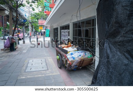 Bangkok, Thailand - August 7, 2015: Bangkok on August 7, 2015.  Junk Collector parked a cart beside the road to look for recycled garbages.