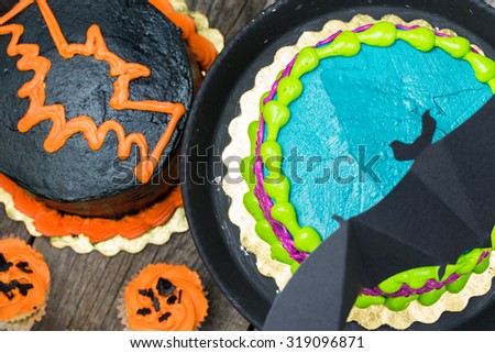 Close up of Halloween butter cream cakes, holiday vanilla cream cupcakes and Halloween decoration.
