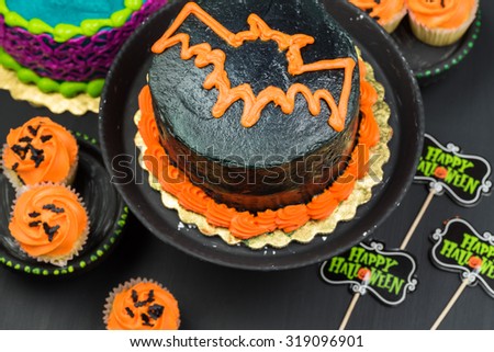 Close up of Halloween butter cream cakes, holiday vanilla cream cupcakes and Halloween decoration.
